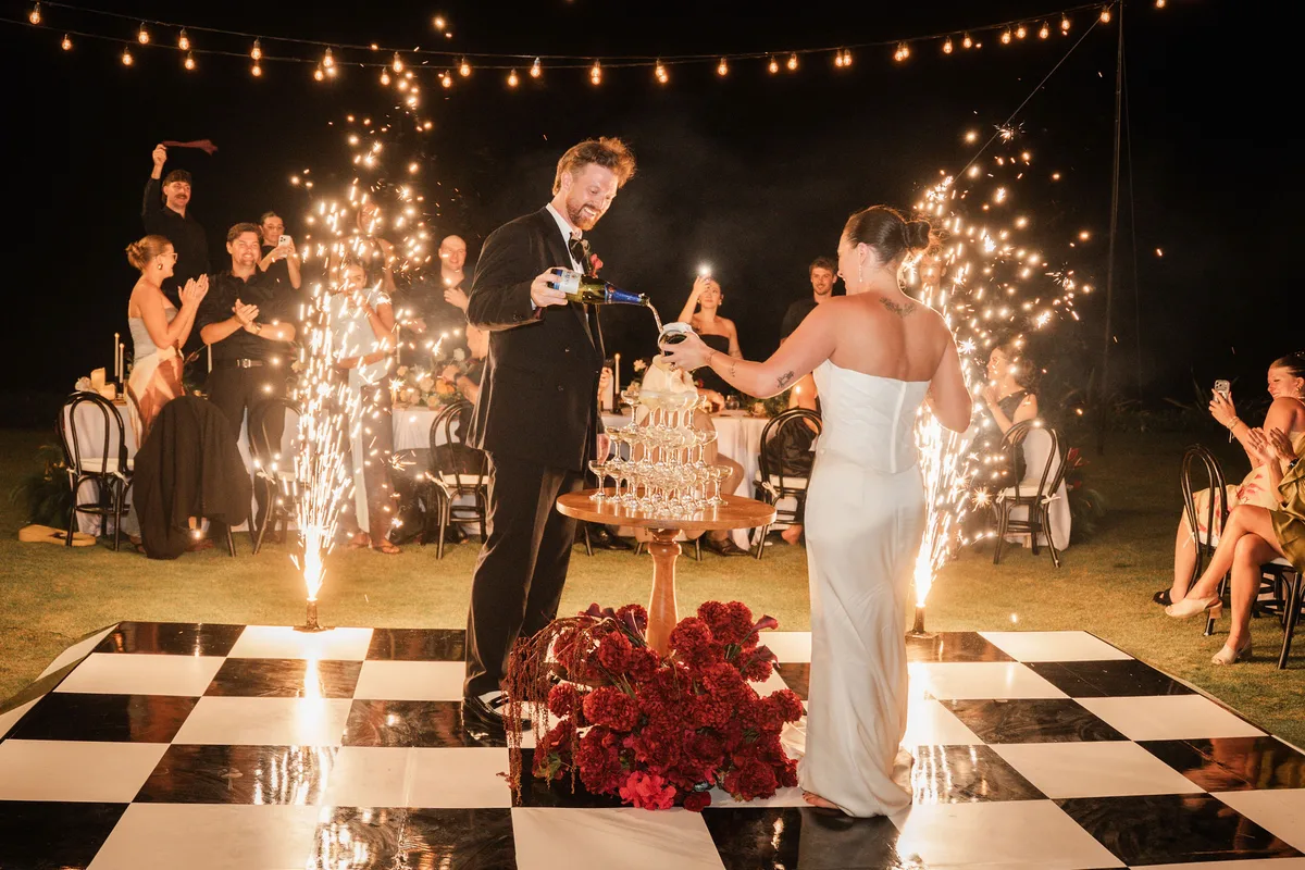 Cake cutting surrounded by cold sparklers at night